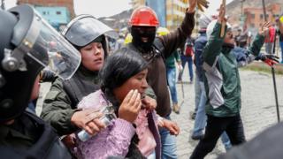 Members of the security forces detain a woman during clashes between supporters of Evo Morales and opposition supporters in La Paz, Bolivia, 11 November, 2019.