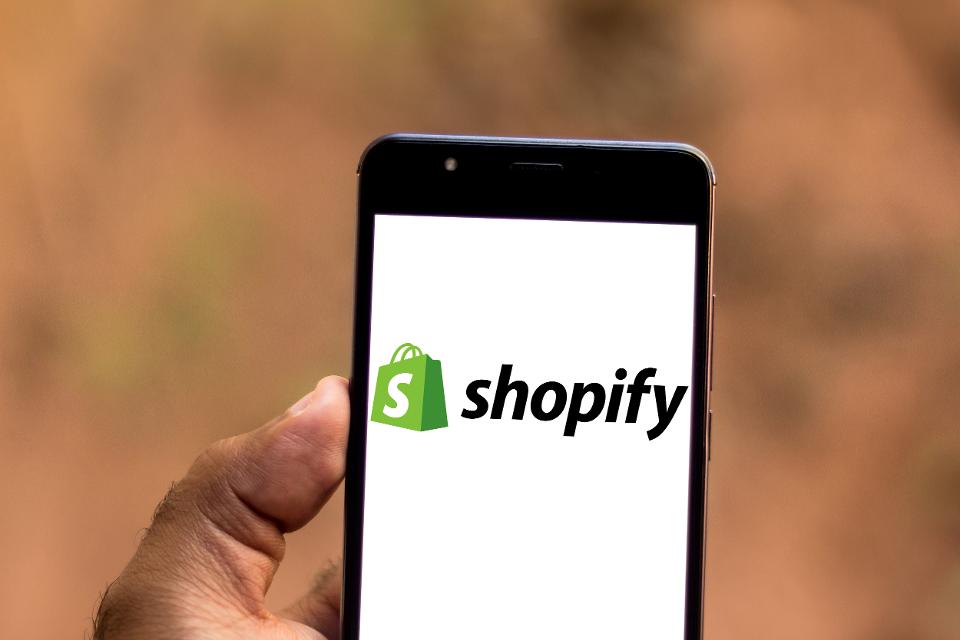In this photo illustration a Shopify logo seen displayed on...