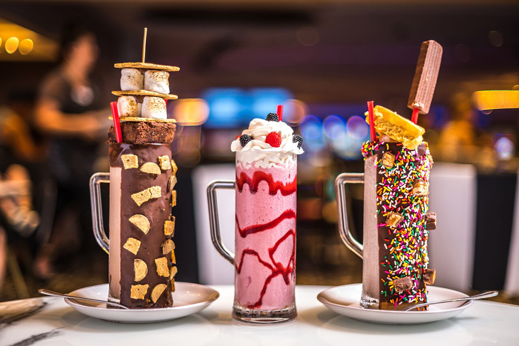 Three milkshakes with sugary toppings