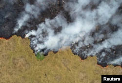 FILE - Smoke rises over a deforested plot of the Amazon jungle in Porto Velho, Rondonia State, Brazil, Aug. 24, 2019.
