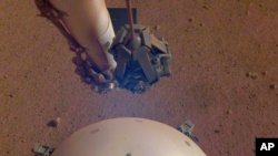 This photo made available by NASA on Tuesday, April 23, 2019 shows the Mars InSight lander's domed wind and thermal shield which covers a seismometer. (NASA/JPL-Caltech via AP)
