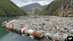 In this photo taken on Tuesday, April 23, 2019, plastic bottles and other garbage float in the river Drina near Visegrad, eastern Bosnia-Herzegovina. (AP Photo/Eldar Emric)