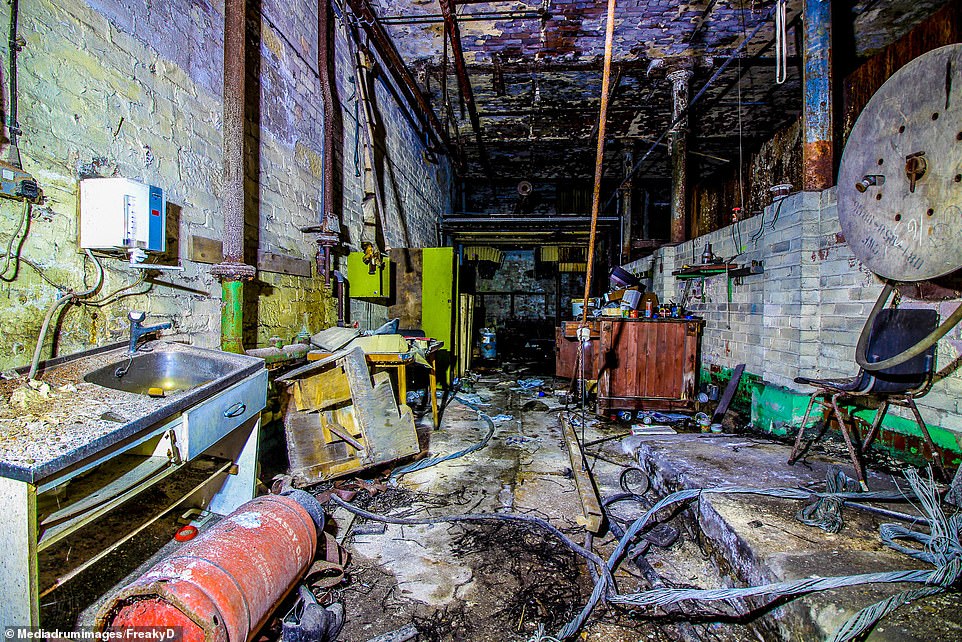 The dilapidated factory is littered with memories of the industrial past showing a broken sink and a floor littered with engineering tools