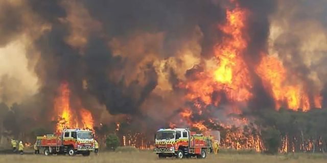 In this image dated Dec. 30, 2019, and provided by NSW Rural Fire Service via their twitter account, firefighters are seen as they try to protect homes around Charmhaven, New South Wales.