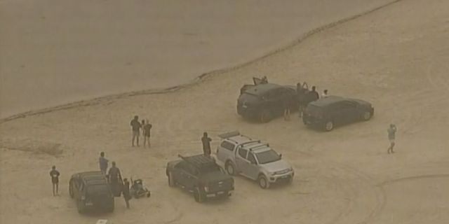 In this image made from video, people evacuate to a lake to escape wildfires Tuesday, Dec. 31, 2019, in Ulladulla, New South Wales, Australia.