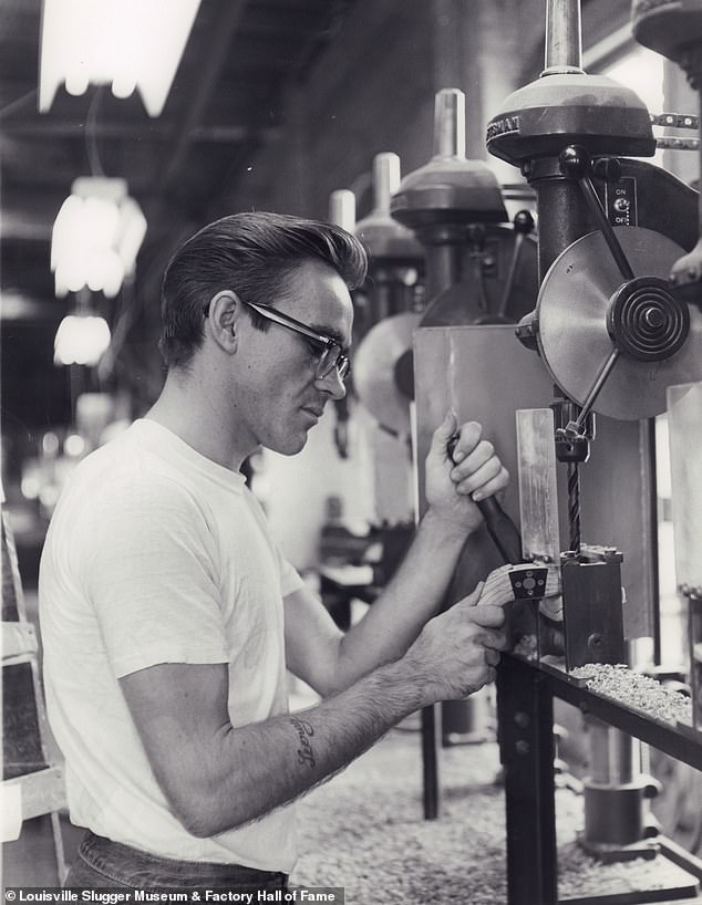 An unidentified man carefully works on a persimmon golf club head at a table saw at the Hillerich and Bradsby company