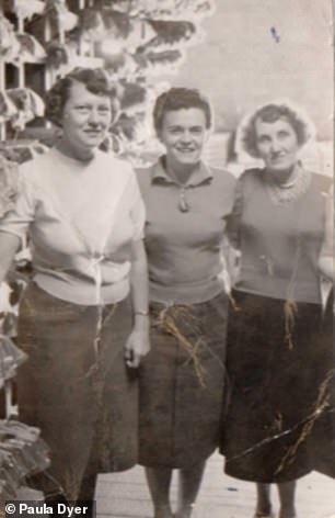 Polly Basham (left) stands with two Hillerich and Bradsby employees in front of a wall of baseball bats