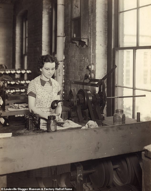 An unnamed employee is pictured meticulously wrapping a golf club