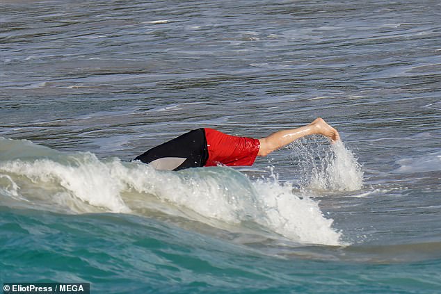 Diving in: Paul couldn't resist taking the plunge as he splashed around in the shallows