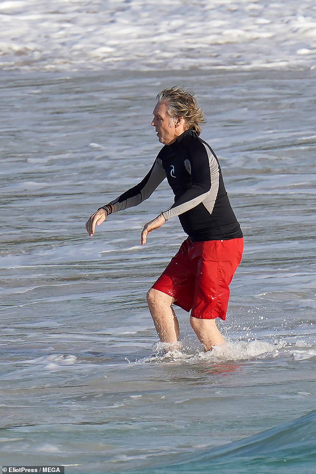 Living it up: After his brief dip in the ocean, Paul went back onto dry land