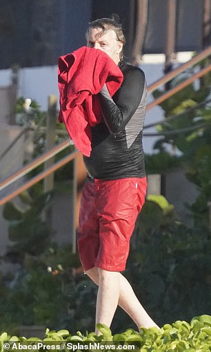 Drying off: He patted his face as he walked along the sand