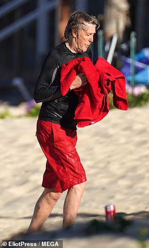 Drying off: Paul dried off as he strolled along the beach with his towel