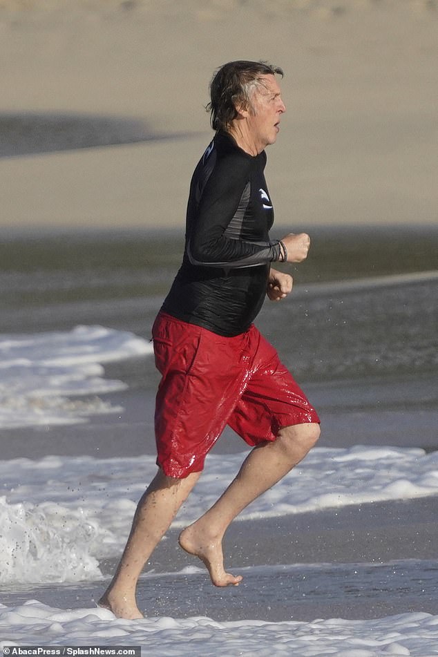 Motivated: He ran through the sea and onto the dry sand after spending some time making the most of his proximity to the water while on his holiday