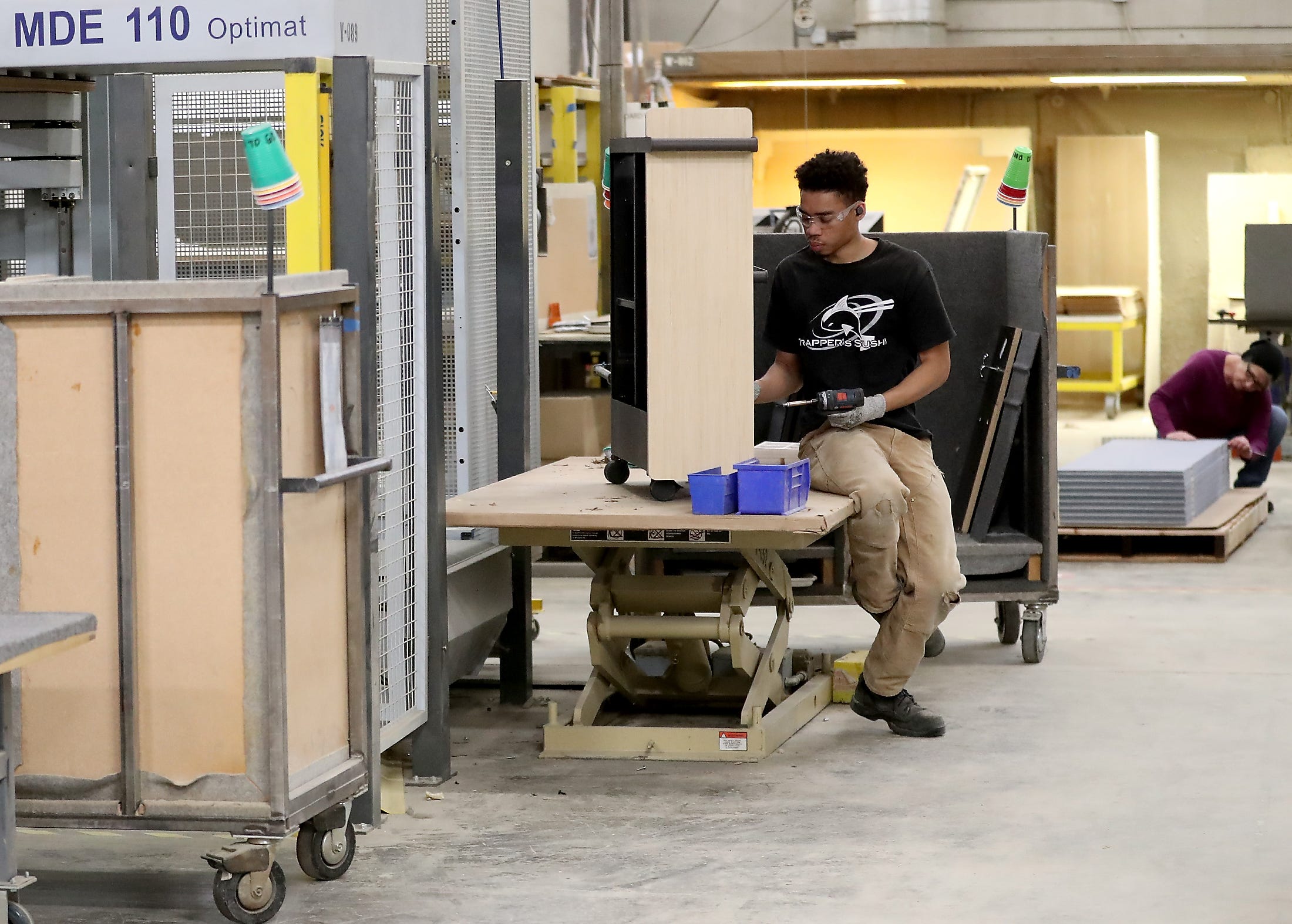 Builder Cedric Crowley assembles a storage unit at Watson Furniture in Poulsbo on Tuesday.