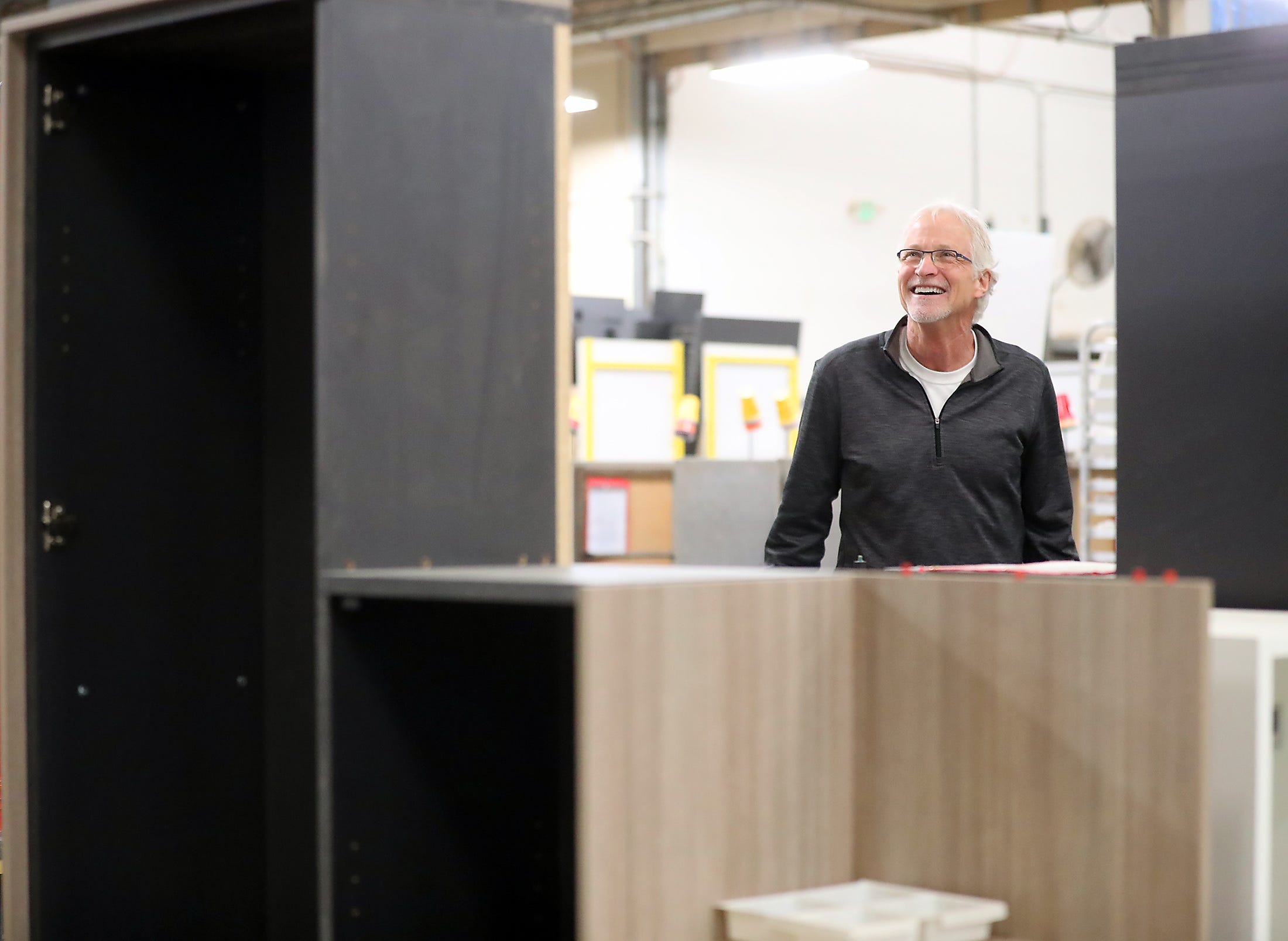 Clif McKenzie, CEO of Watson Furniture, is framed by office furniture in various stages of production as he gives a tour of the factory in Poulsbo on Tuesday.