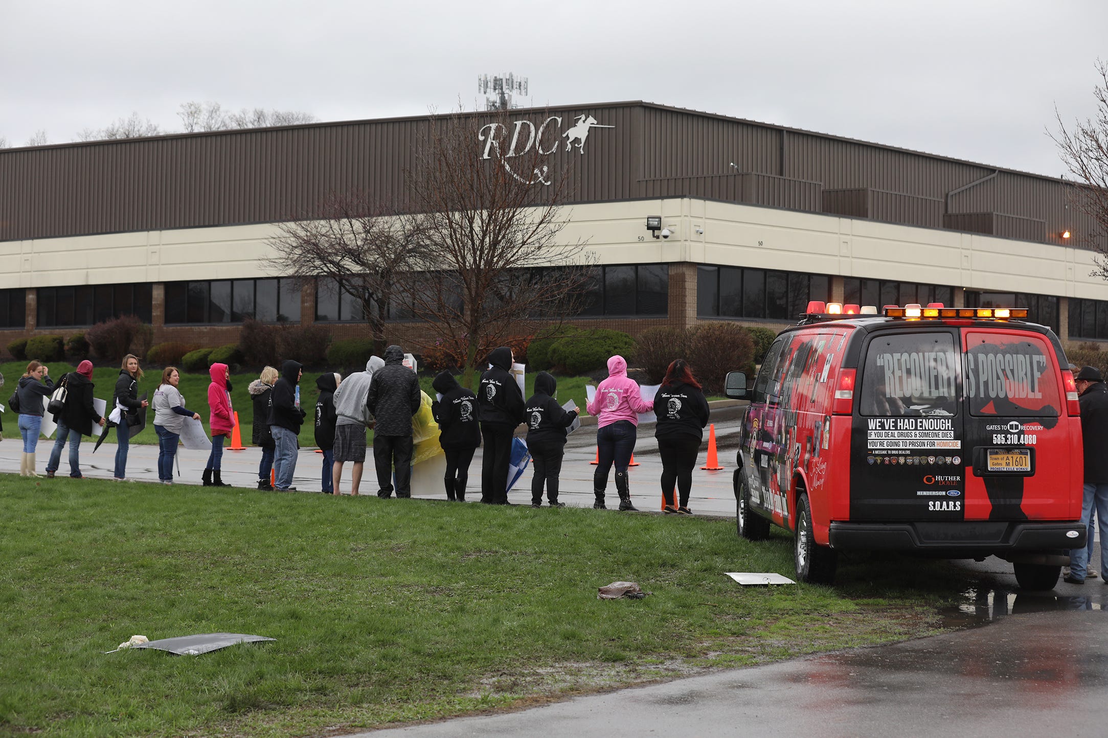 Family's of loved ones hold photos and protest outside RDC, Rochester Drug Cooperative.  The rally was in response to the recent federal charges against RDC.  Gates Police’s van with images of those who died from drugs was also brought to the protest.