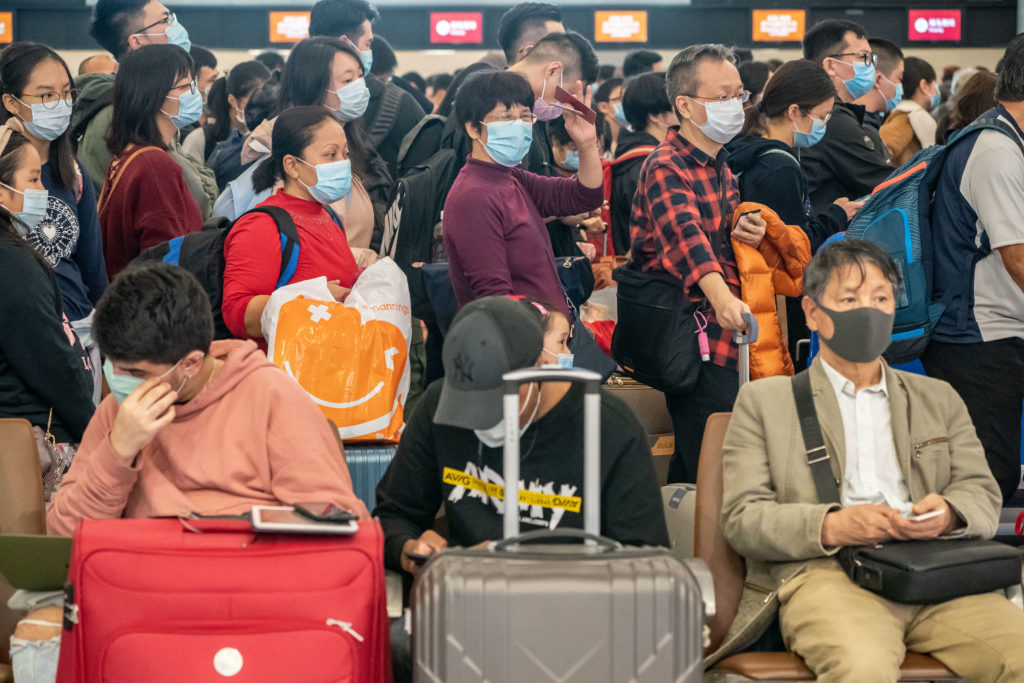 Travelers wearing face mask wait at the departure hall of West Kowloon Station on January 23, 2020 in Hong Kong. (Photo by Anthony Kwan/Getty Images)
