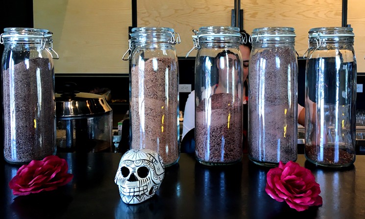 Cultura owner Damaris Ronkanen prepares sipping chocolates behind a row of her own products.