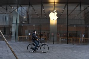 A man cycles past a closed Apple store in Beijing on Feb. 8, 2020. (Credit: GREG BAKER/AFP via Getty Images)