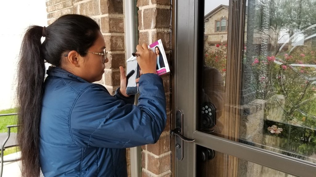 Congressional candidate Jessica Cisneros leaves a flyer at a home in Live Oak, Texas, on Feb. 19, 2020, as she campaigns to unseat Rep. Henry Cuellar, D-Laredo, in the March 3 Democratic primary.