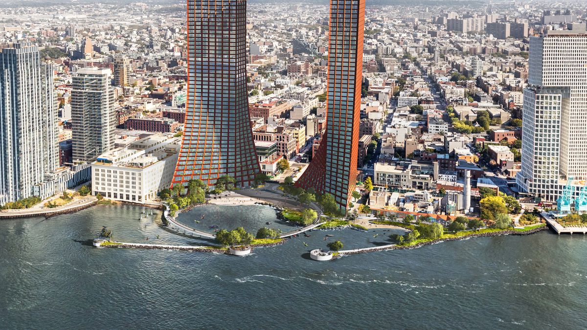 Two glass towers surrounding a waterfront park.