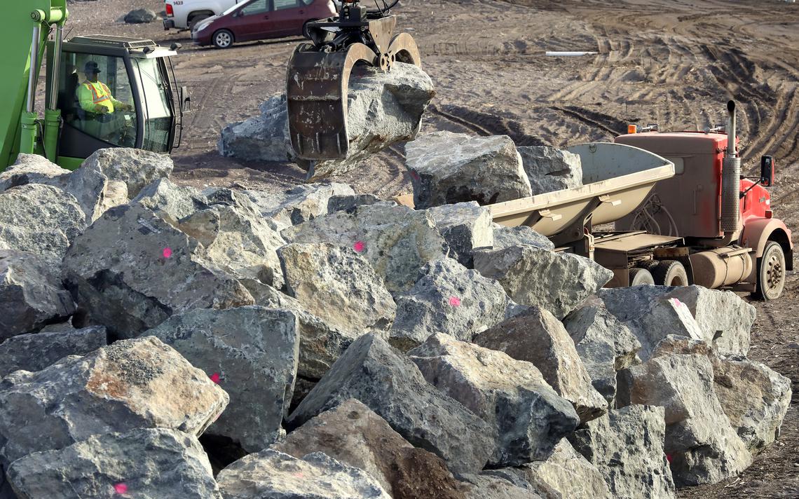 The operator of a Sennebogen material handler adds rocks from a side dump truck to a growing pile on the Canal Park beach. (Steve Kuchera / skuchera@duluthnews.com)