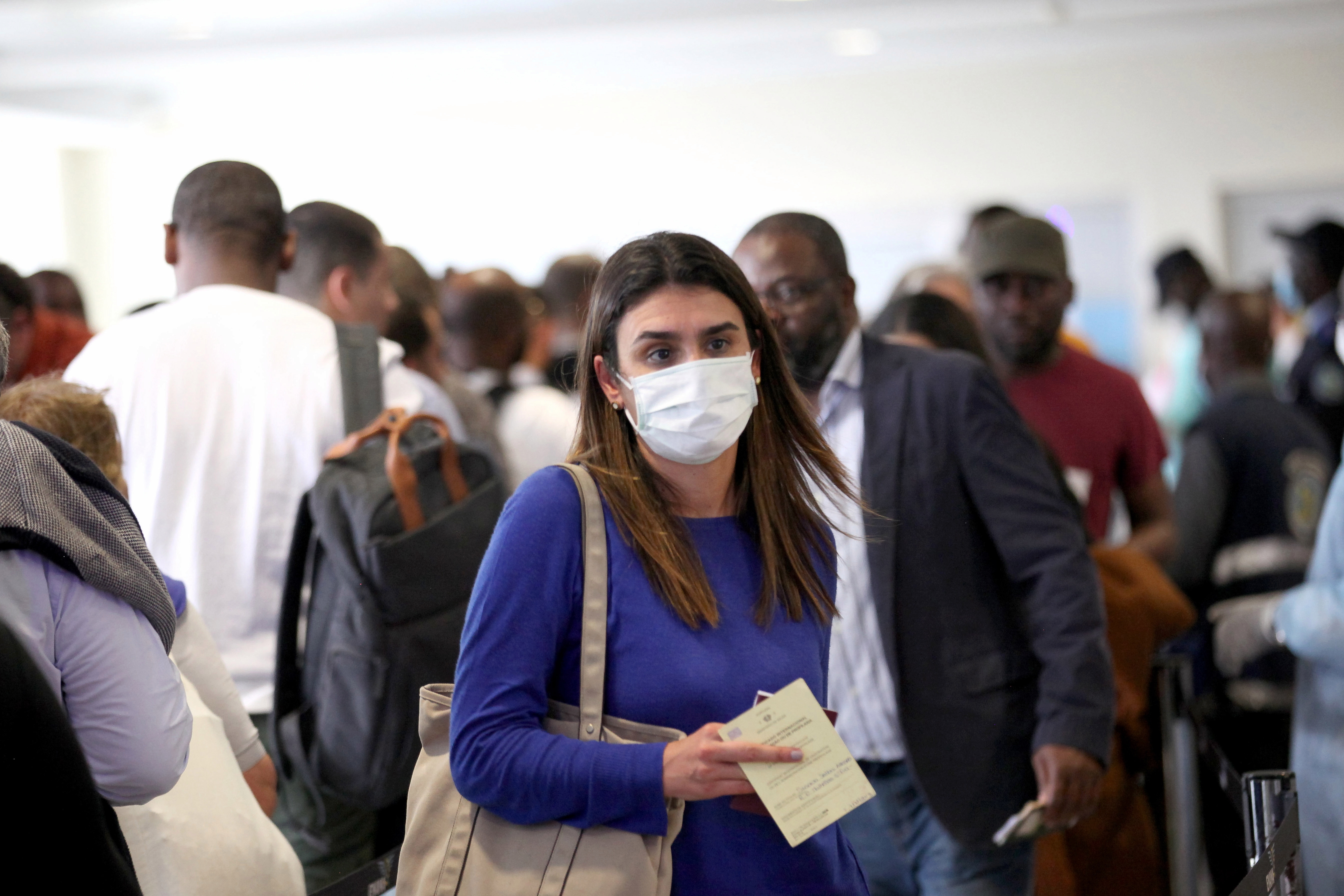 A passenger arriving from Lisbon wearing a medical face mask prepares to be screened in Angola