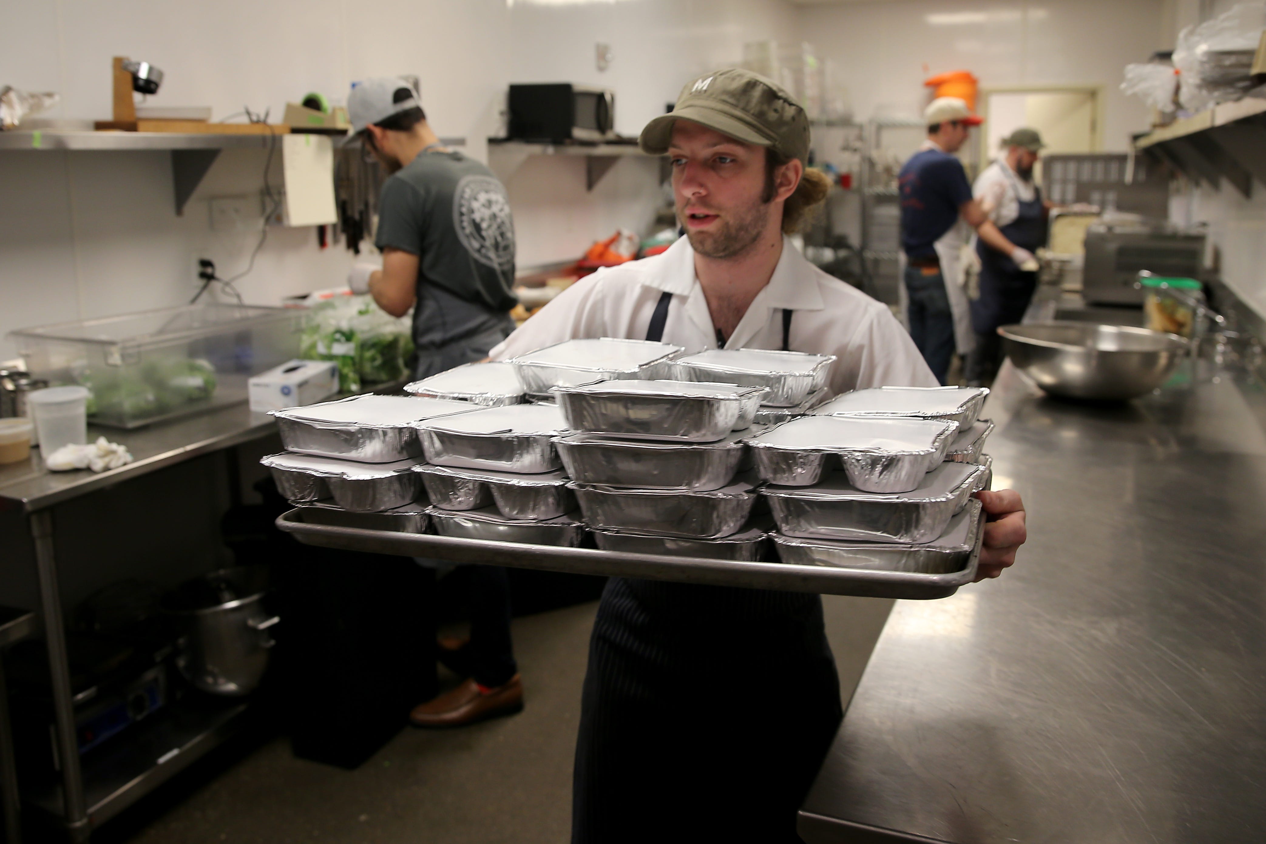 Mita's sous chef Nick Hartshorn works to prepare meals for out-of-work workers from the restaurant and hospitality industries affected by the new coronavirus pandemic, Thursday, March 19, 2020, at Mita's restaurant and bar. The restaurant will open its doors every day between 5 and 8:30 p.m. for laid off restaurant and hospitality workers to offer meals, toiletries, diapers and canned good for the next to weeks. Workers must show identification and a paystub to prove they work in the restaurant or hospitality industries.