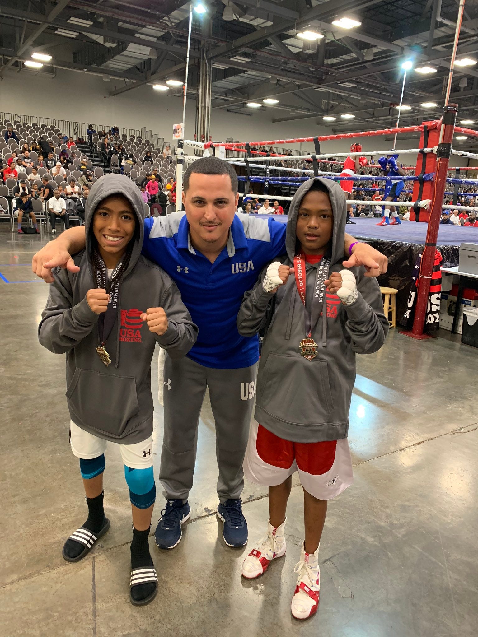 Coach Tim Nolan, center, with two of his young fighters, Javier Mitchell, left, ranked No. 1 in USA at 85 pounds, and Fynest Cummings. Both boxers took home titles at eastern United States qualifier.
