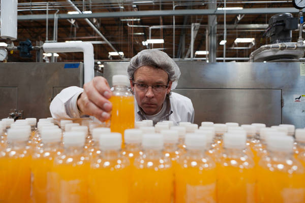 juice factory worker, hairnet, bottle Droits d'auteur IPGGutenbergUKLtd