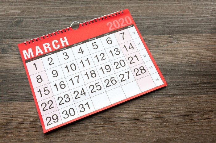 A calendar open to March 2020 on a wooden table.