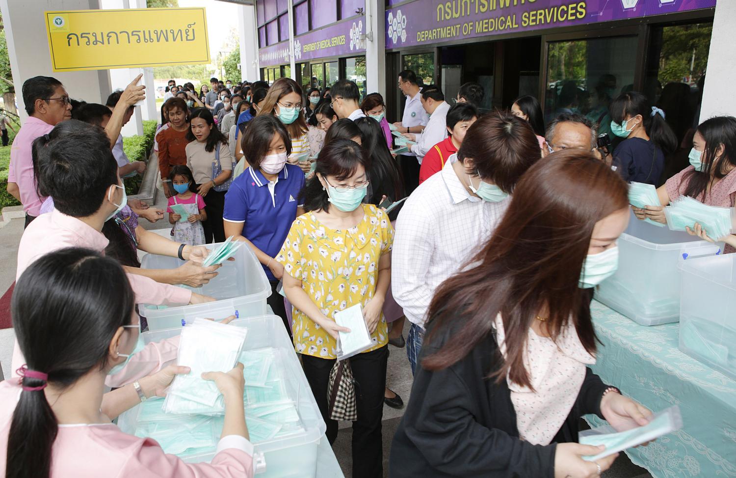 People receive free face masks from the Medical Department at the Public Health Ministry in response to shortages and masks being sold at high prices. Apichit Jinakul People receive free face masks from the Medical Department at the Public Health Ministry in response to shortages and masks being sold at high prices. Apichit Jinakul