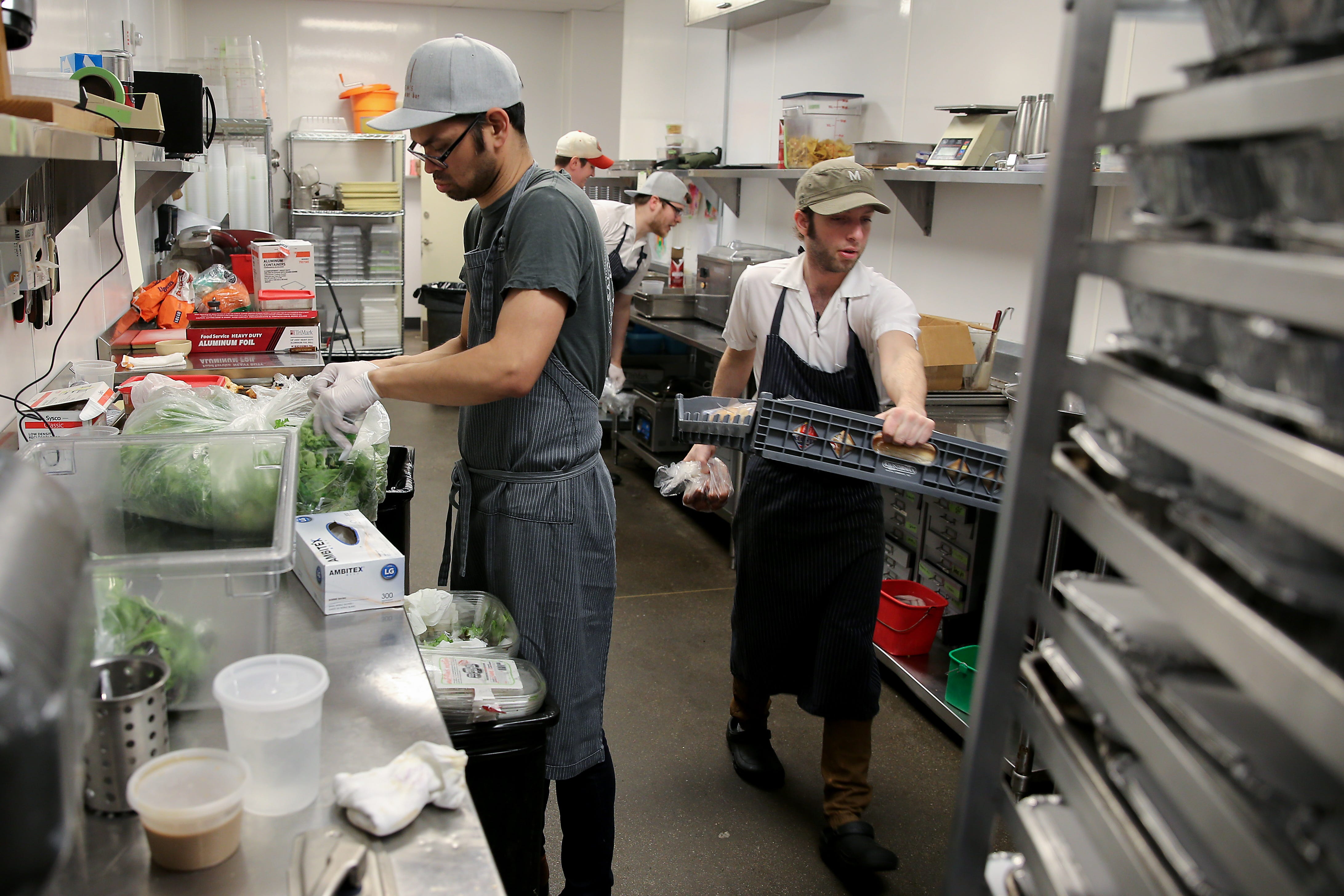 Mita's pastry chef Brian Neumann, left, prepares salads as sous chef Nick Hartshorn works to prepare meals for out-of-work workers from the restaurant and hospitality industries affected by the new coronavirus pandemic, Thursday, March 19, 2020, at Mita's restaurant and bar. The restaurant will open its doors every day between 5 and 8:30 p.m. for laid off restaurant and hospitality workers to offer meals, toiletries, diapers and canned good for the next to weeks. Workers must show identification and a paystub to prove they work in the restaurant or hospitality industries.