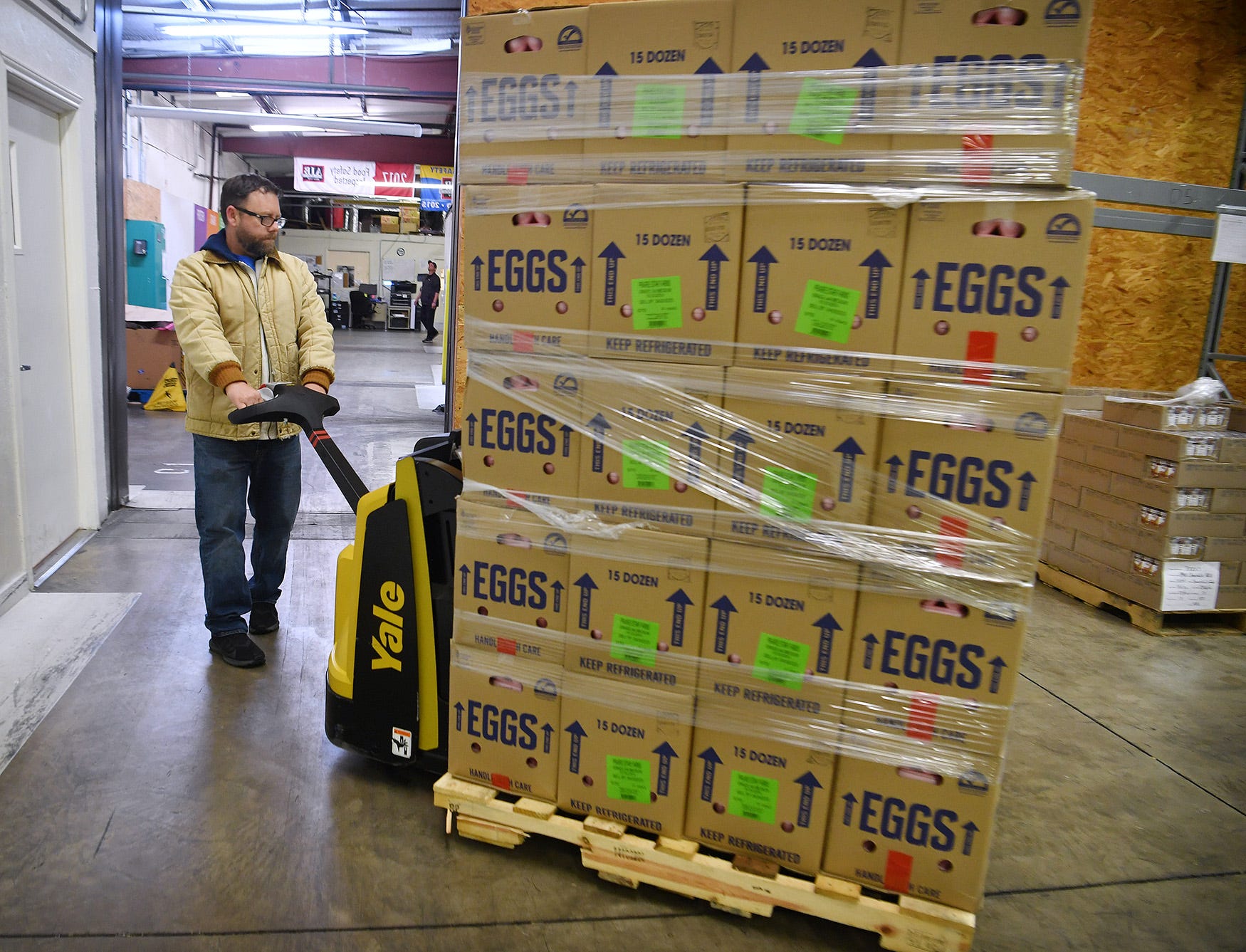 Rusty Williams, operations director for the Wichita Falls Area Food Bank, moves a pallet of fresh eggs in the facility's warehouse Friday. 