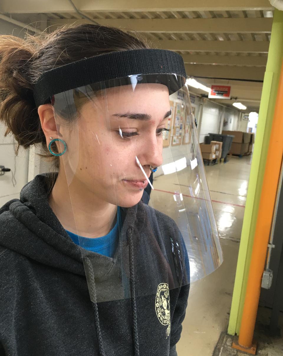 Disc Makers employee tests a face shield prototype