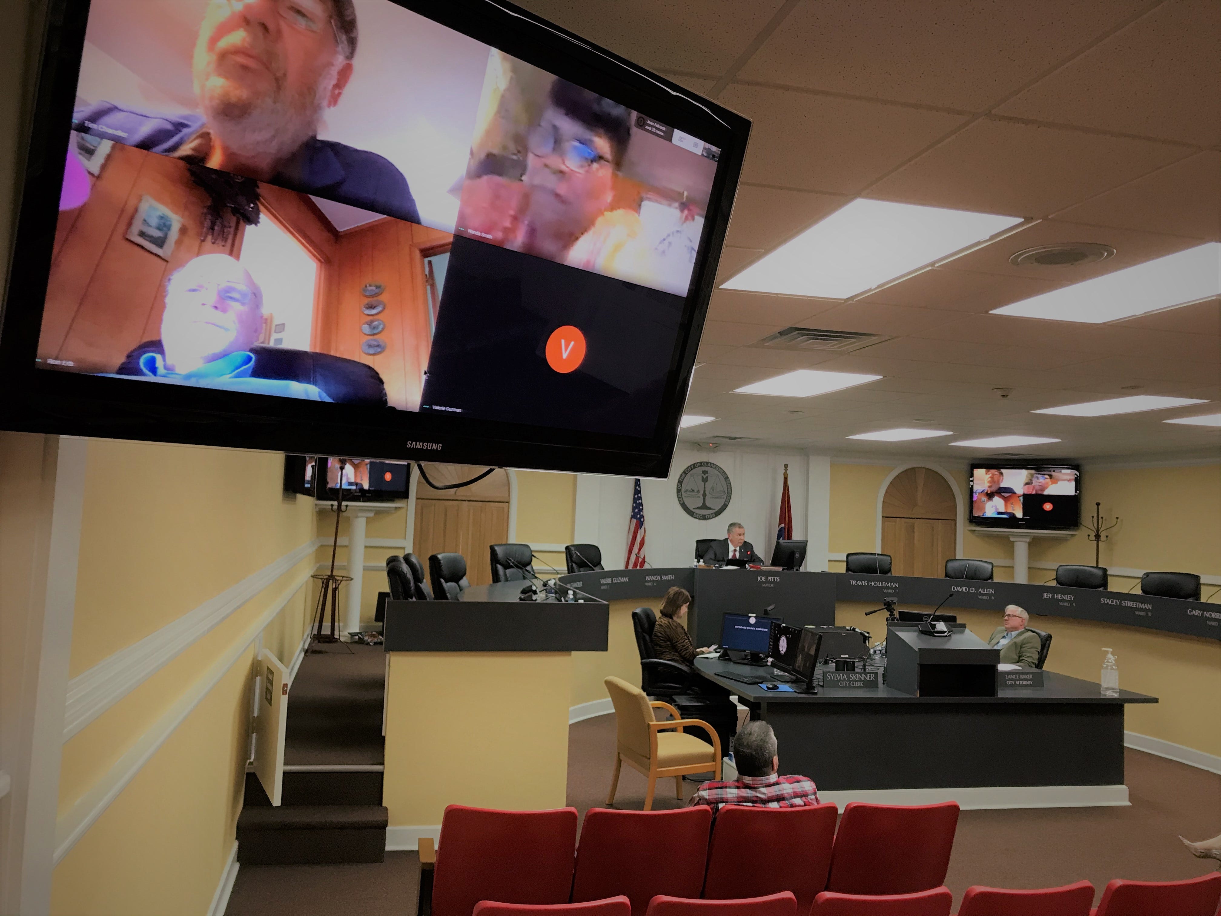 The Clarksville City Council meets for the first time over Google Meet for its informal session on Thursday, March 26, 2020. Mayor Joe Pitts, center, was the only elected official in the mostly empty room, while the council members, normally seated around him, took part from home by video, shown in monitors around the room. This was part of a coronavirus safety measure.
