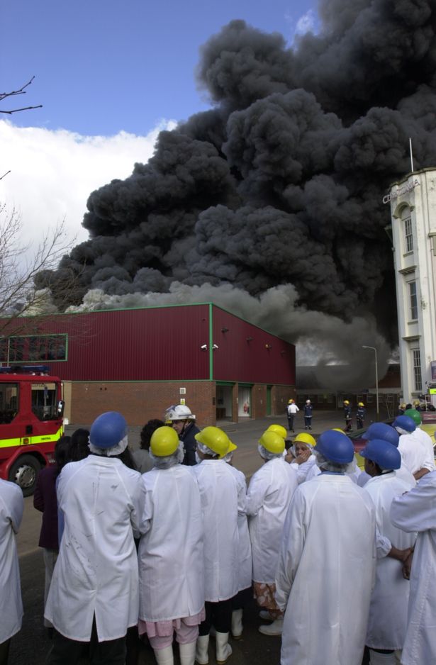 Workers watch as the Mayur Foods Factory on Dysart Way, Leicester, is engulfed by fire in March 2001