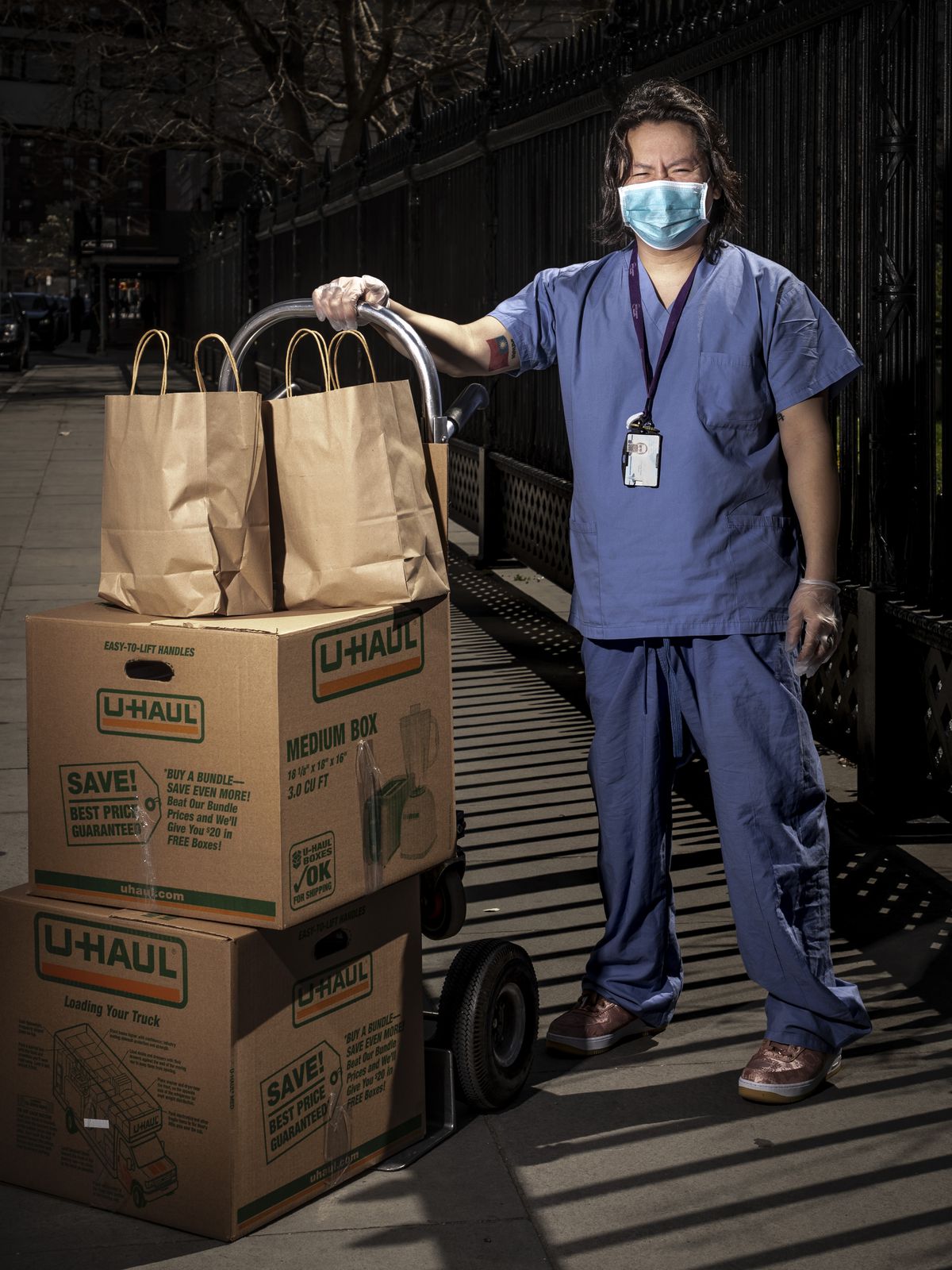 Surgical technologist Henry Chung receives a boxes of food while wearing his scrubs and face mask