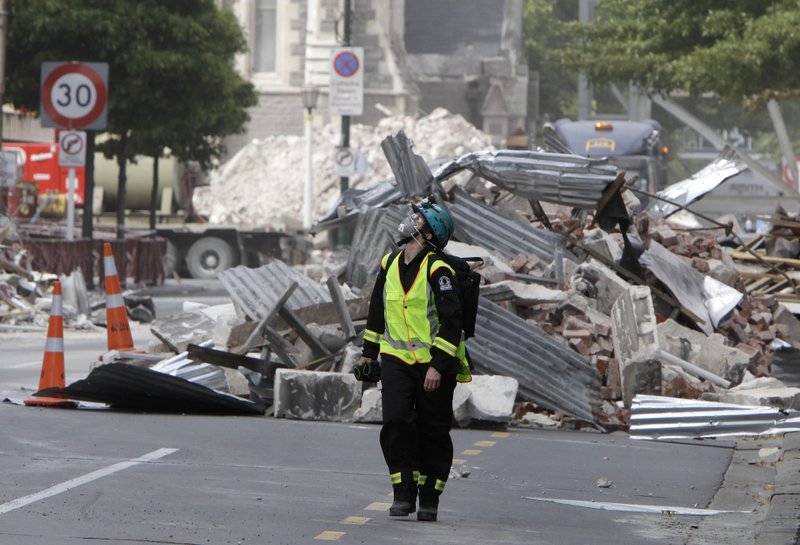 FILE- In this March 2, 2011, file photo, a New Zealand Urban Search and Rescue worker walks through the central business district during a search of earthquake damaged buildings in Christchurch, New Zealand. The virus outbreak is compromising the ability of nations to prepare for natural disasters and deal with the aftermath. Every year, the world contends with devastating typhoons, wildfires, tsunamis and earthquakes. (AP Photo/Mark Baker Pool, File) story.lead_photo.caption