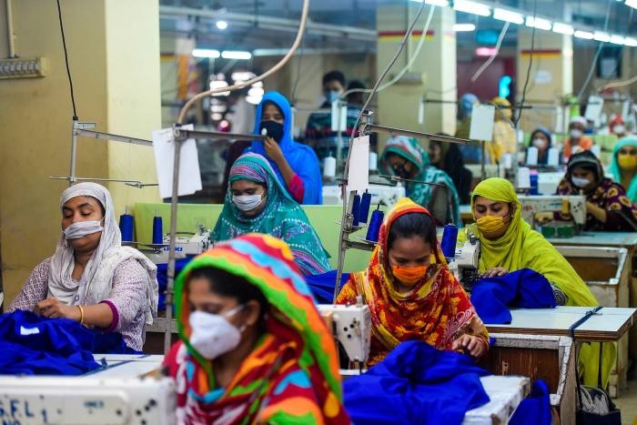 Labourers wear face masks in a garment factory in Dhaka.Bangladesh industry groups estimate that over half of its textile workforce has already been laid off