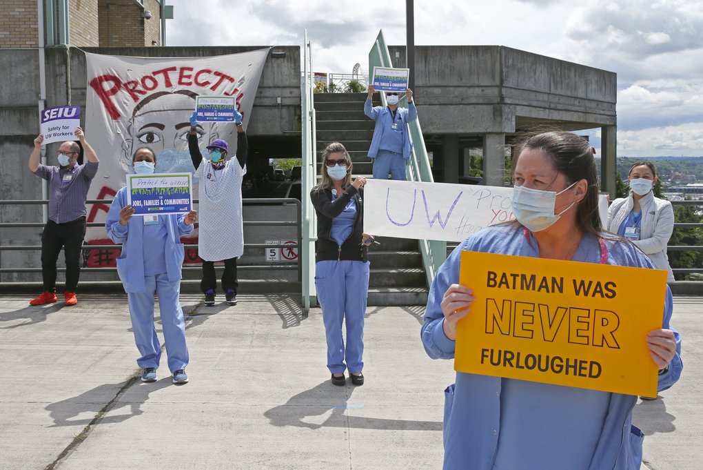 Unionized UW Medicine staff and labor organizers keep a healthy distance from each other during a “unity break” demonstration outside Harborview Medical Center in Seattle on Thursday.  On Monday, UW Medicine officials announced one- to eight-week furloughs for 1,500 professional staff, which includes management and administrative workers.(Ken Lambert / The Seattle Times)