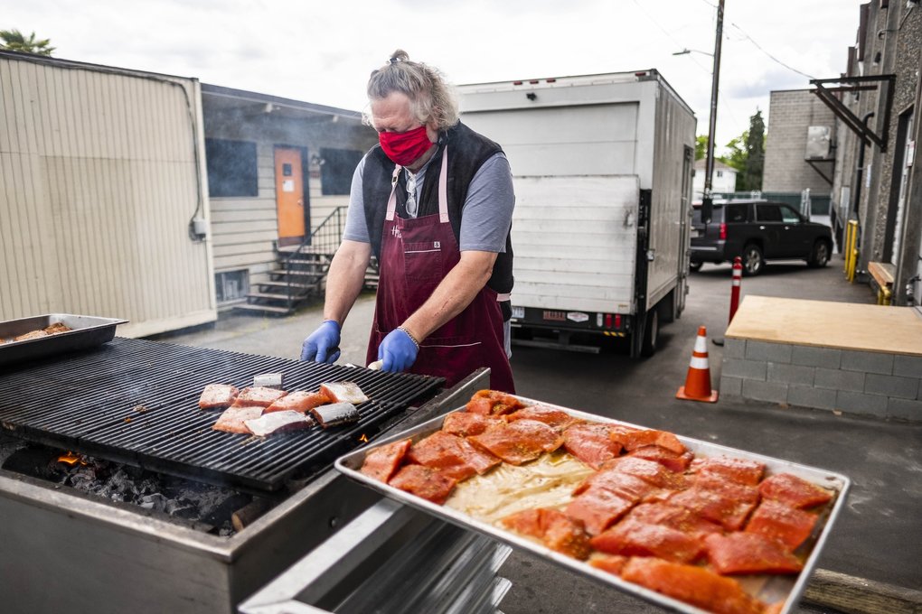 Seattle restaurateur Tom Douglas grills the first Copper River salmon of the year to reach the city as part of his Grilling For Good charity Sunday in his Ballard warehouse. Douglas partnered with Trident Seafoods, Ocean Beauty Seafoods, Alaska Airlines and the Copper River Marketing Association to create 400 dinners, each sold at $45, the proceeds of which went entirely to Food Lifeline. (Dean Rutz / The Seattle Times) 