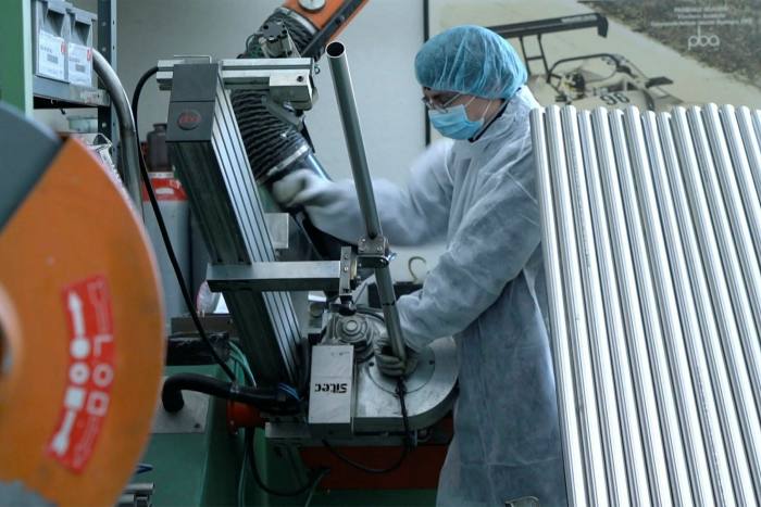 Employees in full personal protective equipment at work in the factory