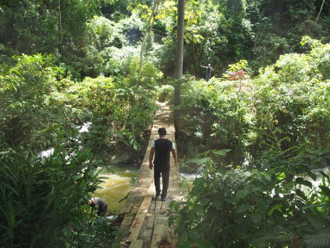 A man crosses a bridge in Peru’s Central Jungle, January 2020. (Photo by Thomas Grisaffi)