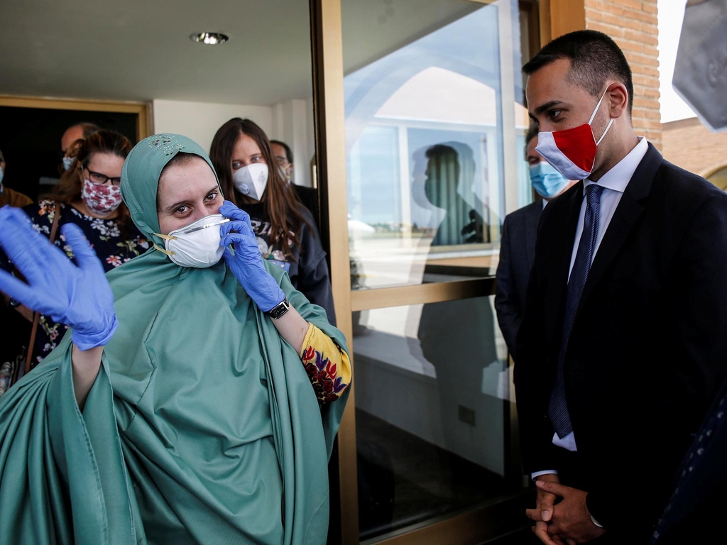 Silvia Romano, an Italian aid worker who was kidnapped by gunmen in Kenya 18 months ago, waves next to Italian Foreign Minister Luigi Di Maio at Ciampino military airport in Rome, Italy, May 10, 2020 Reuters