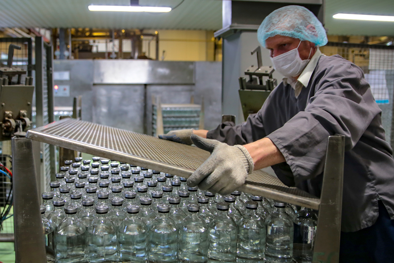 A man in a facemask works at a production facility of the pharmaceutical company Escom, which manufactures saline solution, glucose solution, and other infusion and injection solutions in Stavropol, Russia, on May 6. The factory has moved to round-the-clock production during the pandemic. Alexander PogozhevTASS via Getty Images