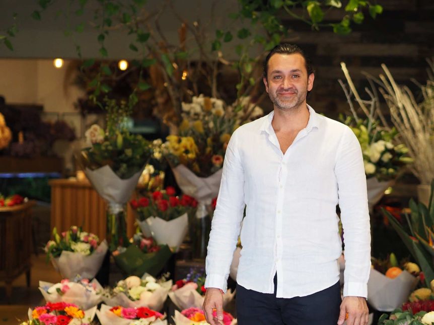 Sydney florist george pizanis standing in front of an arrangement of flowers