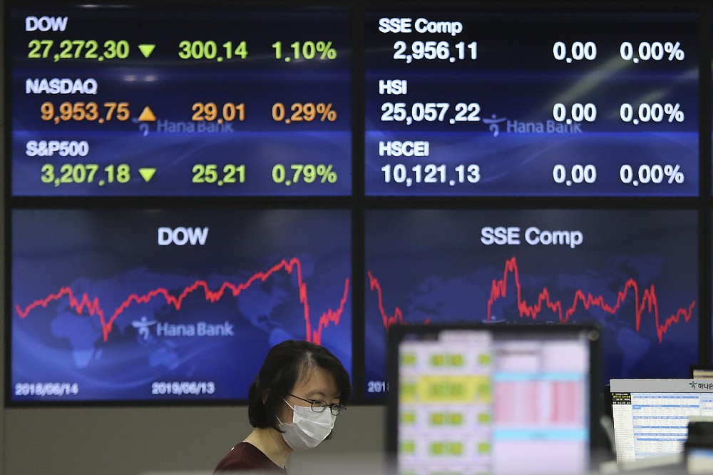 A currency trader watches monitors at the foreign exchange dealing room of the KEB Hana Bank headquarters in Seoul, South Korea, Wednesday, June 10, 2020. Shares were trading slightly higher in Asia on Wednesday after a weekslong rally on Wall Street hit the brakes. (AP Photo/Ahn Young-joon)