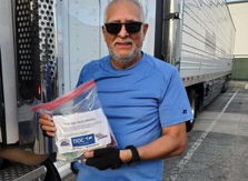 Man standing next to truck with PPE kit