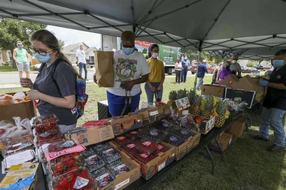 Skyler Cox, from left, and Cheryl Barrett shop for fruits and vegetables at the inaugural Fields of Dover Neighborhood Produce Market at 6239 Ironmill Creek on Friday. The two-hour extravaganza of fresh fruits and vegetables, was held for residents of the subdivision outside of Converse. Photo: Marvin Pfeiffer /Staff Photographer / **MANDATORY CREDIT FOR PHOTOG AND SAN ANTONIO EXPRESS-NEWS/NO SALES/MAGS OUT/TV